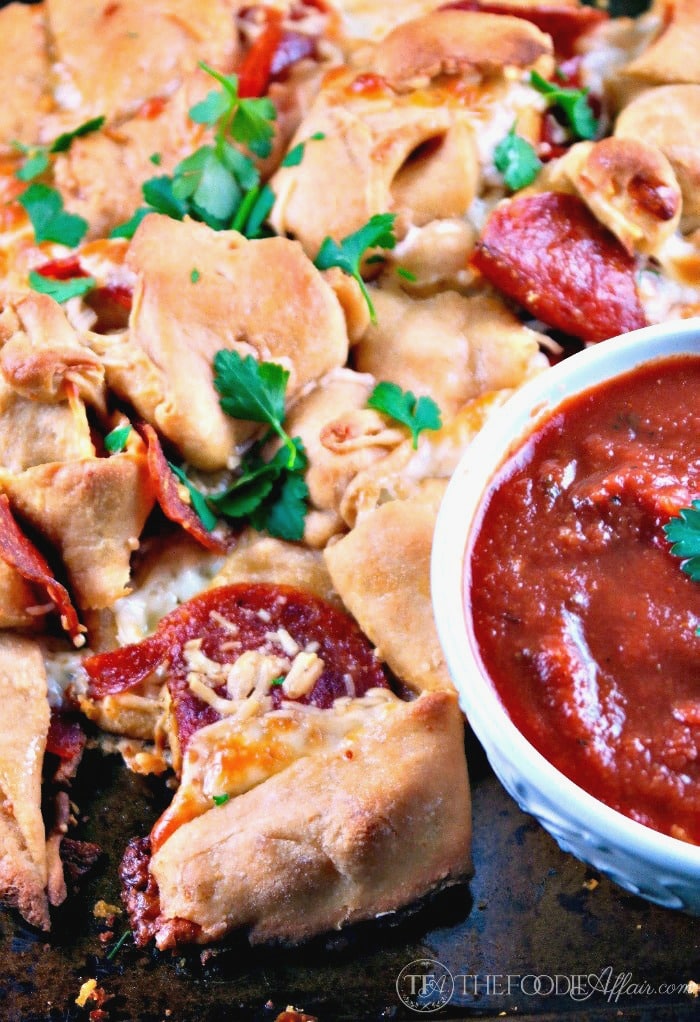 This pull apart pizza bread is packed with cheese and pepperoni and rapped in pizza dough! Dip in pizza sauce! The Foodie Affair